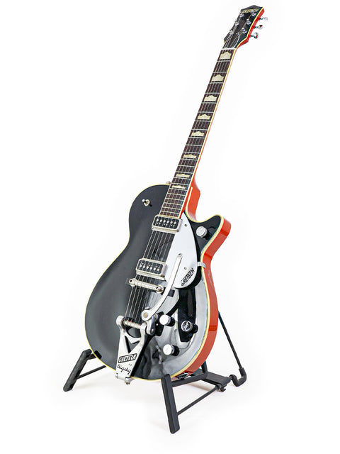 Stunning black and red Gretsch Duo Jet guitar on a stand, perfect for collectors and musicians seeking vintage style.