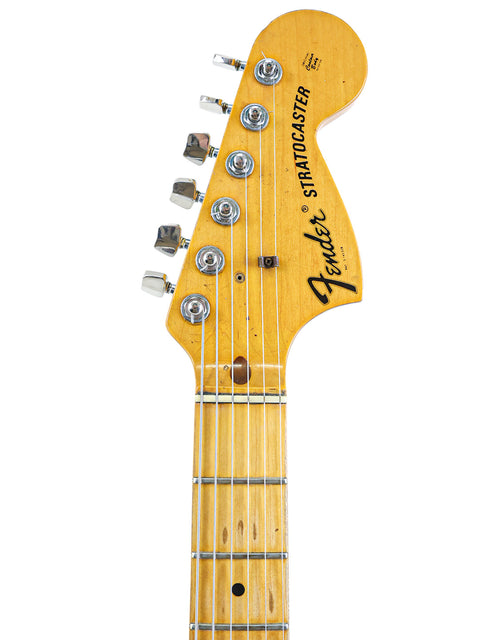 The image features a classic 1974 Fender Stratocaster, a true icon of American guitar history.