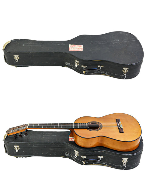 Two guitars side by side; one is in a protective case while the other is open, set against M.G. Contreras Calle Mayor 80, Spain, 1973.