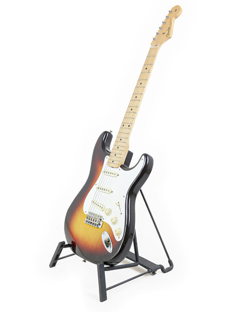 Vintage 1958 Fender Stratocaster guitar elegantly positioned on a stand with a bright white background.