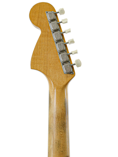 Vintage 1967 Fender Mustang guitar head in close-up, emphasizing the rich wood grain and classic features.