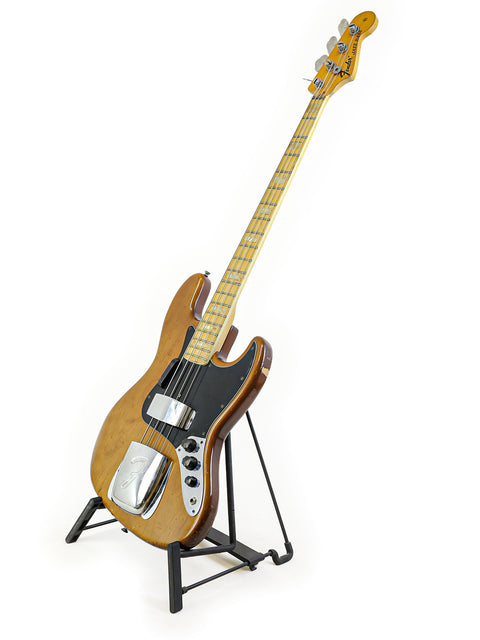 Vintage Fender Jazz Bass from 1974 showcased on a stand with a plain white background.
