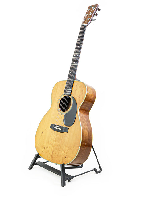 Vintage Martin 000-28 guitar from 1974 showcased on a stand with a plain white background.