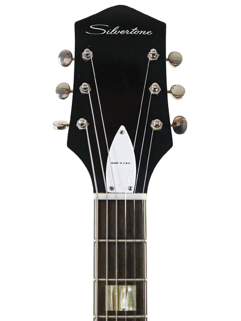 Vintage Silvertone 1446 guitar from 1961-65, highlighted by its white pickguard and stylish black headstock.