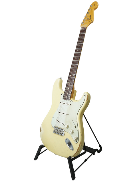White '64 Stratocaster guitar on a black stand, highlighting its relic design from the Fender Custom Shop, USA 2009.