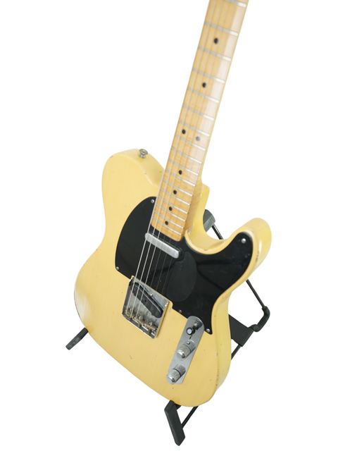 Yellow electric guitar on a stand, showcasing the Fender Custom Shop Cunetto Nocaster Relic from 1998, USA-made.