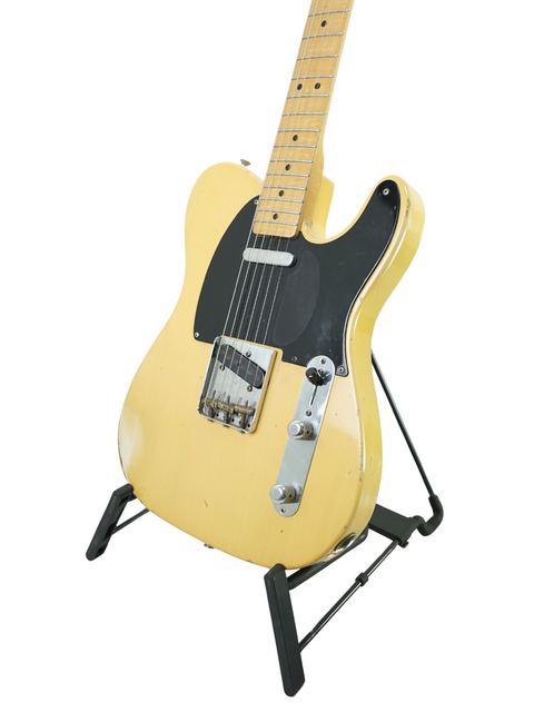 ellow electric guitar on a stand, featuring the Fender Custom Shop Cunetto Nocaster Relic from 1998, USA-made.