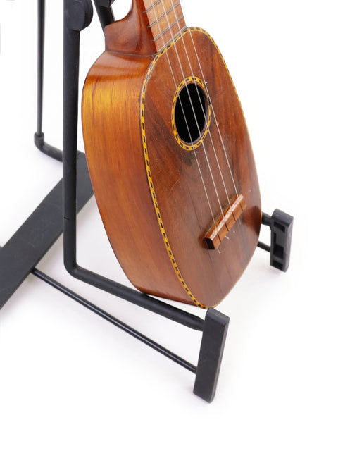 1928 Kamaka Pineapple Style #3 ukulele displayed on a stand, showcasing its classic design.