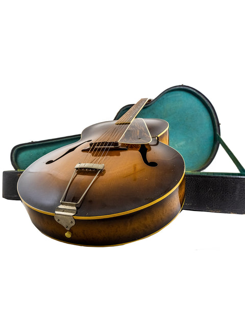 1940s Vintage Gibson L 7 Special guitar nestled in a case, set against a white backdrop, emphasizing its historical significance.