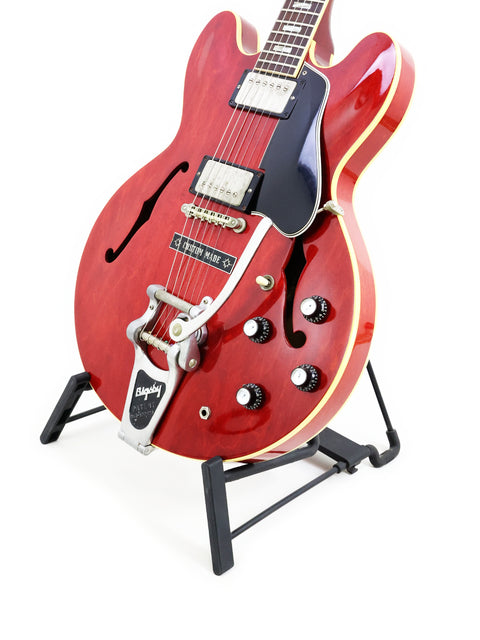 1963 Gibson ES-335 in red on a stand, highlighted by its black pick guard.