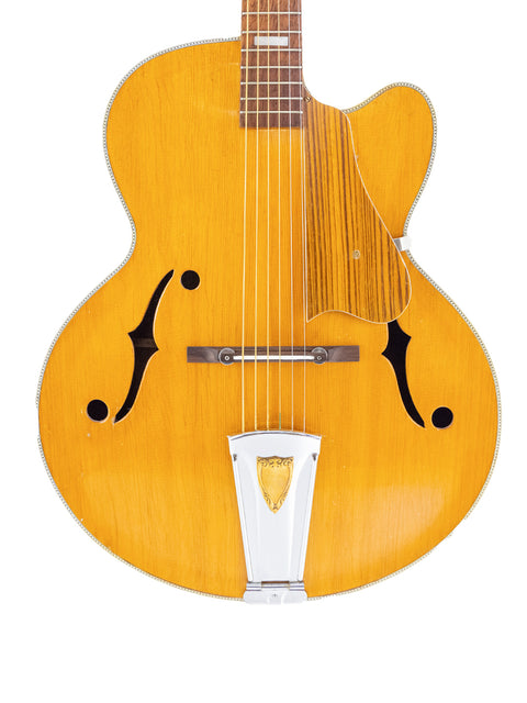 1970s Sutton Archtop guitar, bright yellow body and a sleek white pick guard.