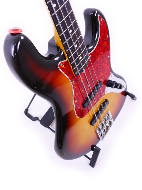 1986/87 Fender Jazz Bass guitar with a vibrant sunburst finish, representing a blend of artistry and musical excellence.