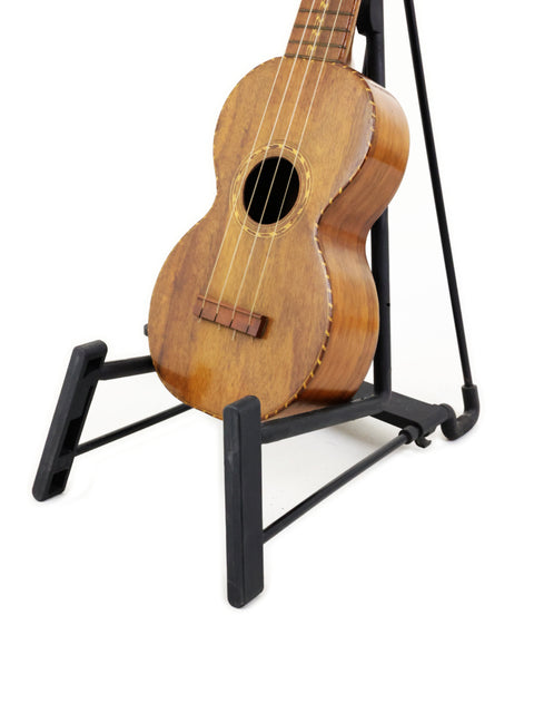 A 1920s Nuuanu Style 4 Koa Ukulele from Hawaii, beautifully positioned on a stand.
