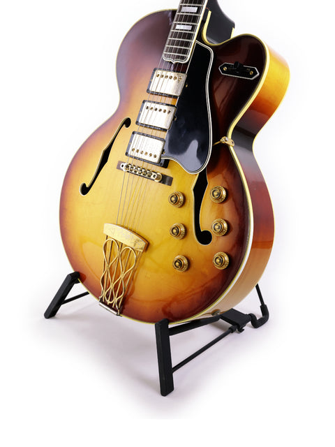 A 1959 Gibson ES-5 Switchmaster guitar positioned on a stand, representing vintage elegance and musical heritage.