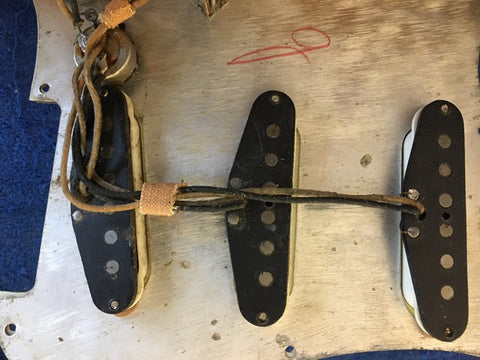 A 1964 Fender L Series Stratocaster in Fiesta Red, showcasing four strings on its iconic vintage design.