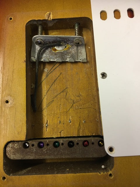 A 1964 Fiesta Red Fender L Series Stratocaster featuring a damaged pickup and visible wiring.