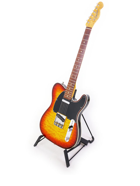 A 1998 Fender Custom Shop 50s Telecaster guitar displayed on a stand, set against a minimalist white backdrop.