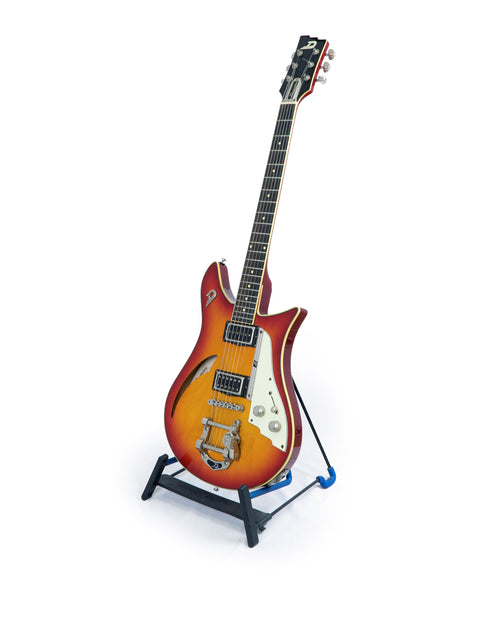 A Duesenberg Double Cat guitar from 2007 displayed on a stand, featuring a striking design against a white backdrop.
