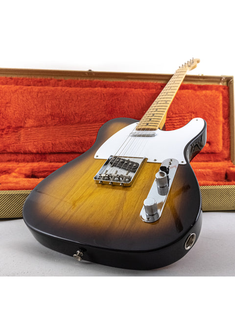 A Fender American Vintage ’58 Telecaster guitar with a striking sunburst finish, securely placed in its protective case.