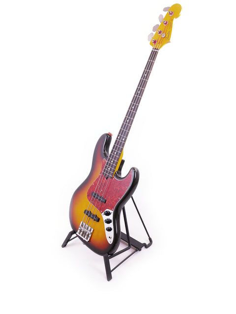 A Fender Jazz Bass, made in Japan (1986/87), showcased on a stand with a minimalist white background.