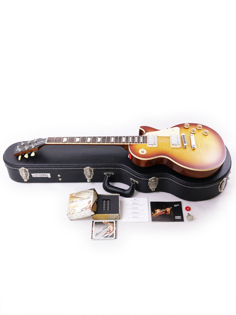 A Gibson Les Paul Traditional guitar from 2013, displayed with its case and accessories, showcasing its classic design.