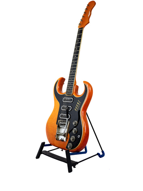 A Warmoth Strat Partscaster guitar from 2012 resting on a stand, highlighted by a simple white background.