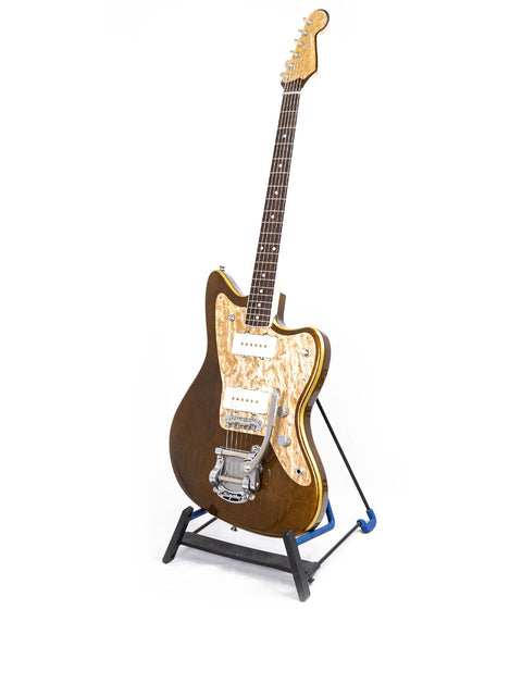 A beautiful wooden guitar displayed on a stand, representing the Zachary & Mercer Mastermind “Deluxe” Offset, Aust 2021.