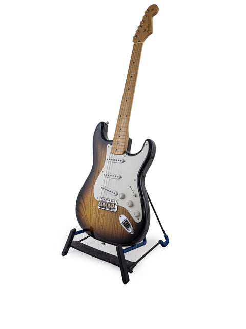 A beautifully crafted Fender Custom Shop 1954 Strat guitar displayed on a stand, with a pristine white backdrop highlighting its features.