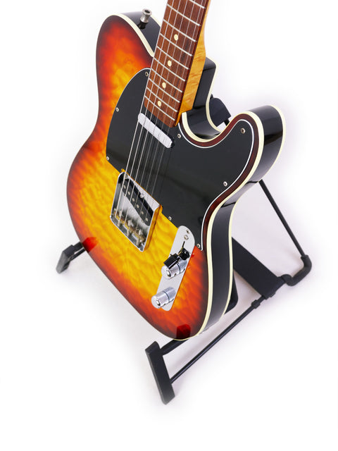 A beautifully crafted Fender Custom Shop 50s Telecaster guitar in sunburst finish, showcased on a stand for display.