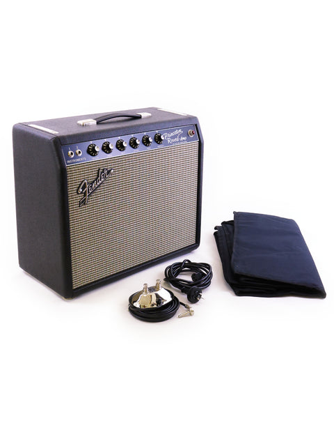 A black-cased Fender Stratocaster and a black cloth, positioned near a '64 Custom Princeton Reverb Combo Amplifier.