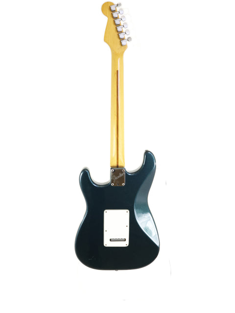 A black Fender Strat Plus Deluxe electric guitar from 1989, featuring a white pickup, showcasing its classic design.