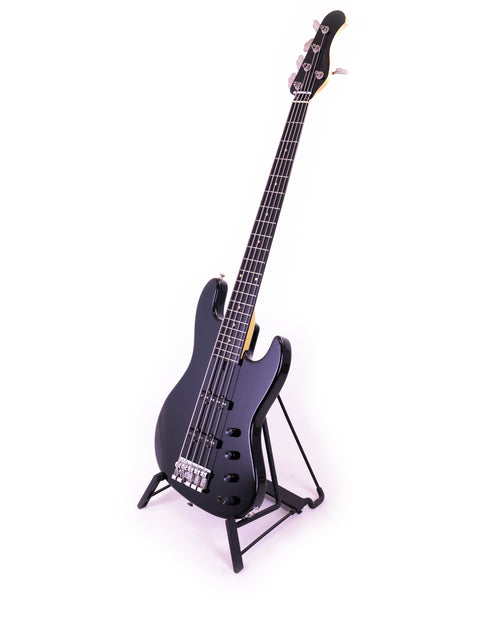 A black Sadowsky NYC Jazz Bass 5 String guitar displayed on a stand with a white backdrop.