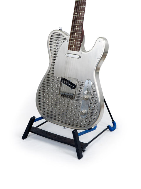 A blue-based stand holding a James Trussart Holey Nickel Steelcaster guitar, emphasizing its distinctive features and style.