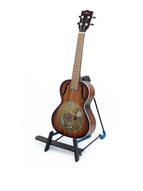 A blue stand holding a Kala KA-RES-BRS Tenor Resonator Ukulele, emphasizing its beautiful craftsmanship and design.
