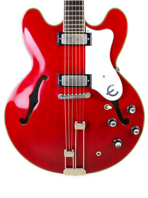 A bold red electric guitar with a white body, highlighting the Epiphone 50th Anniversary 1962 Sheraton E212T Reissue from 2012.