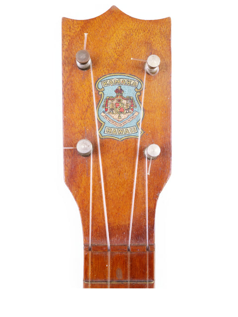 A classic 1928 Kamaka Pineapple Style #3 ukulele with an ornate crest adorning the headstock.
