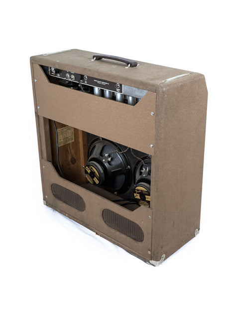 A classic 1961 Fender 6G12A Concert Amp is placed on a wooden box, highlighting its vintage charm and craftsmanship.