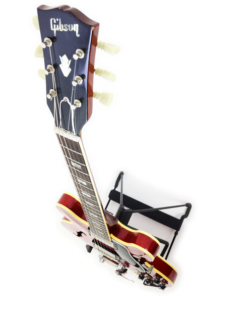 A classic 1963 Gibson ES-335 guitar on a stand, representing vintage elegance and musical history.