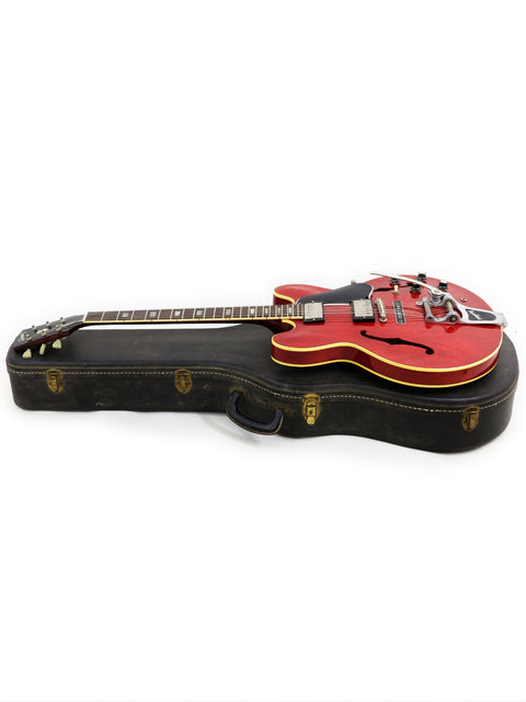 A classic red Gibson ES-335 from 1963 displayed in its case, emphasizing its vintage appeal and craftsmanship.