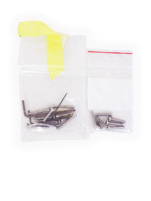 A collection of screws in a bag alongside a yellow bag, highlighting the Lollar B.S. Telecaster Bridge Pickup, USA 2009.