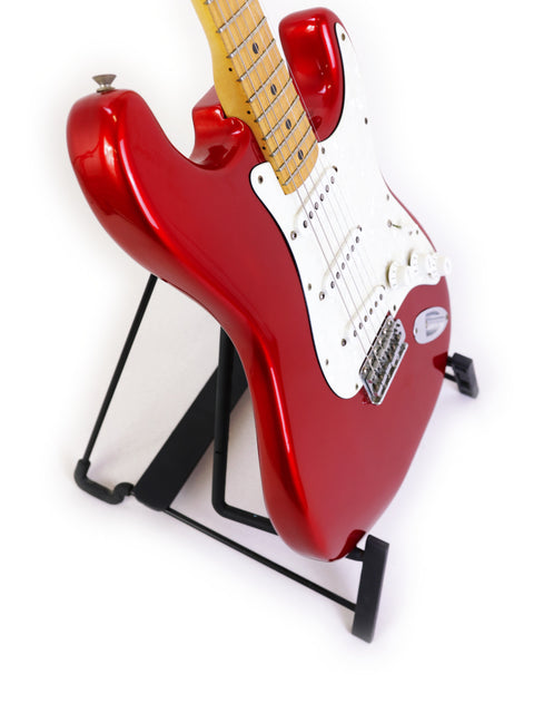 A red Fender Stratocaster guitar on a stand, set against a clean white background, showcasing its vintage 1979 design.