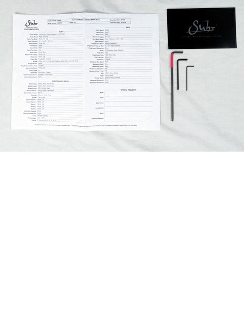 A sheet of paper accompanied by a pen and scissors, highlighting the Suhr Classic Pro – USA 2018.