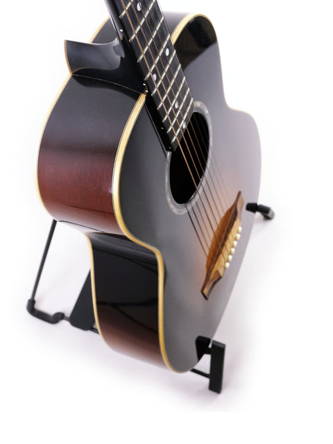 A sleek black acoustic guitar displayed on a stand, representing the Beau Hannam Parlour from Australia, made in 2009.