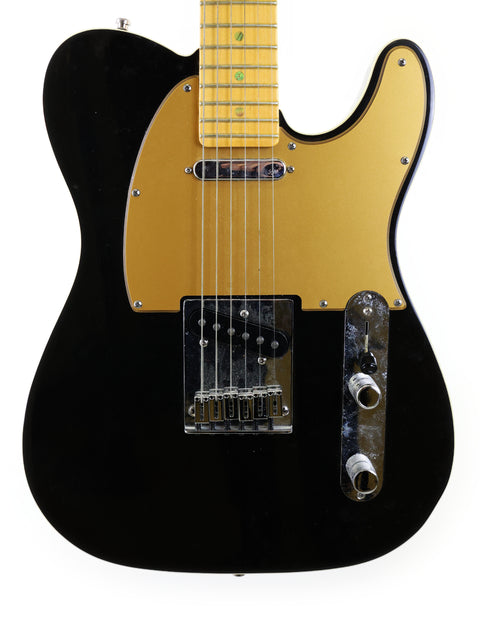A sleek black and gold Fender American Deluxe Telecaster from 2005, featuring a shiny gold pickguard that enhances its style.