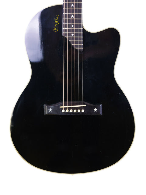 A sleek black guitar, the Gibson Chet Atkins SST from 1998, highlighted by a striking white pick guard for a classic look.