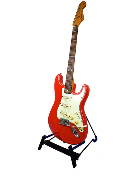 A striking Fiesta Red Fender American Vintage 62 Strat guitar displayed on a stand, set against a plain white backdrop.