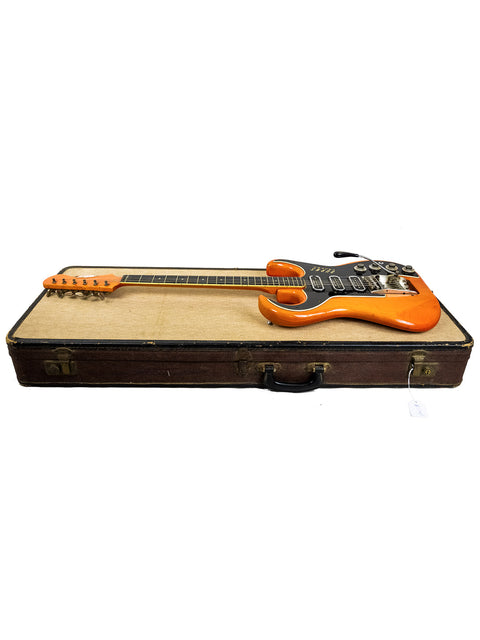 A striking orange Fender Telecaster guitar in a brown case, representing vintage vibes from the UK in 1964.