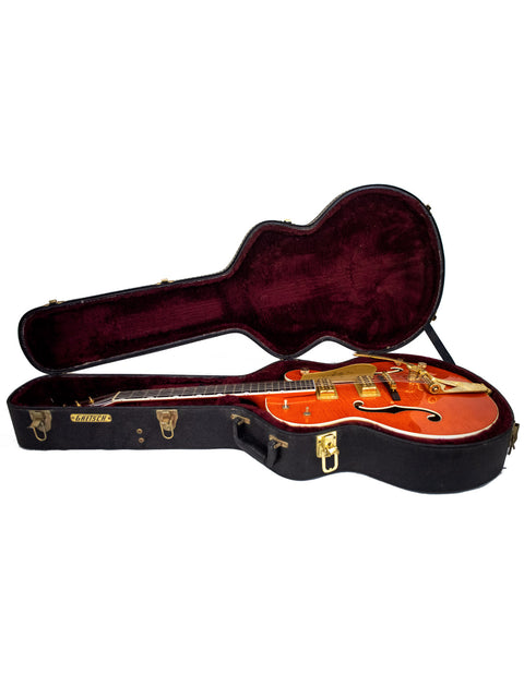 A striking orange guitar, the Gretsch Chet Atkins G6120, displayed in its case, emphasizing its vintage appeal from Japan, 2011.