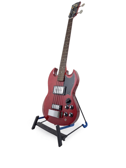 A striking red electric guitar displayed on a stand, highlighting its eye-catching appearance and musical potential.