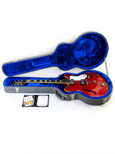 A striking red guitar nestled in a blue case, representing the Epiphone 50th Anniversary 1962 Sheraton E212T Reissue from 2012.